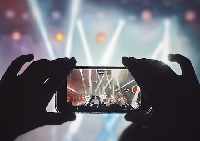Person at a music event recording a video on their phone